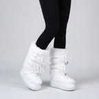 Pair of women's fur lined snow boots set on the snow